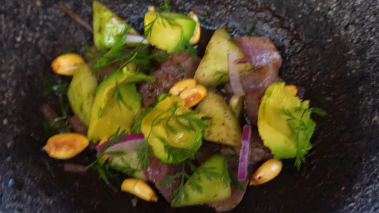 Guest tasting the finished aguachile negro with a spoon