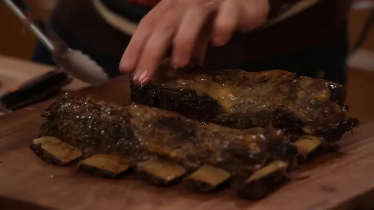 Beef short ribs laid out on a chopping board showing the bones