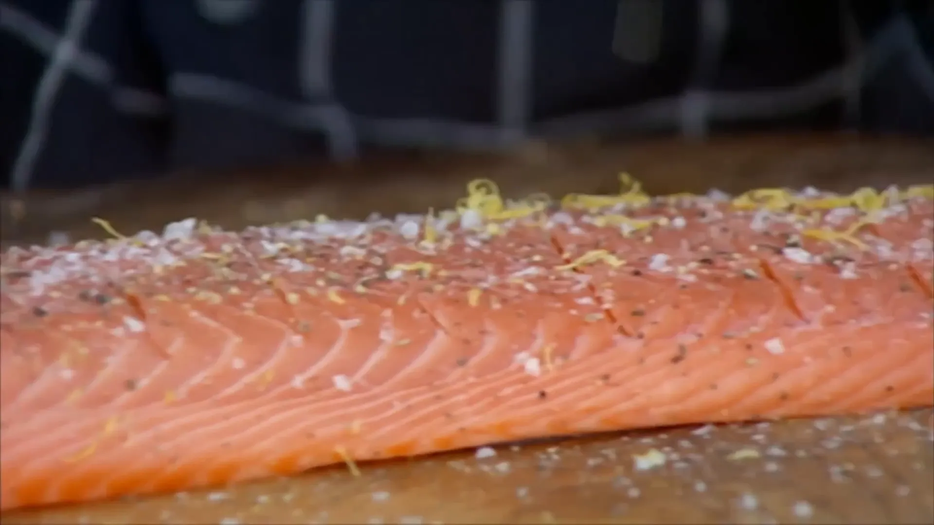 Scoring and seasoning the salmon with salt, pepper, and lemon zest