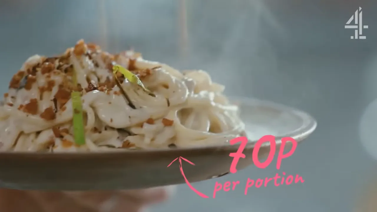 Close-up of creamy cauliflower cheese spaghetti on a plate topped with toasted garlic crumbs