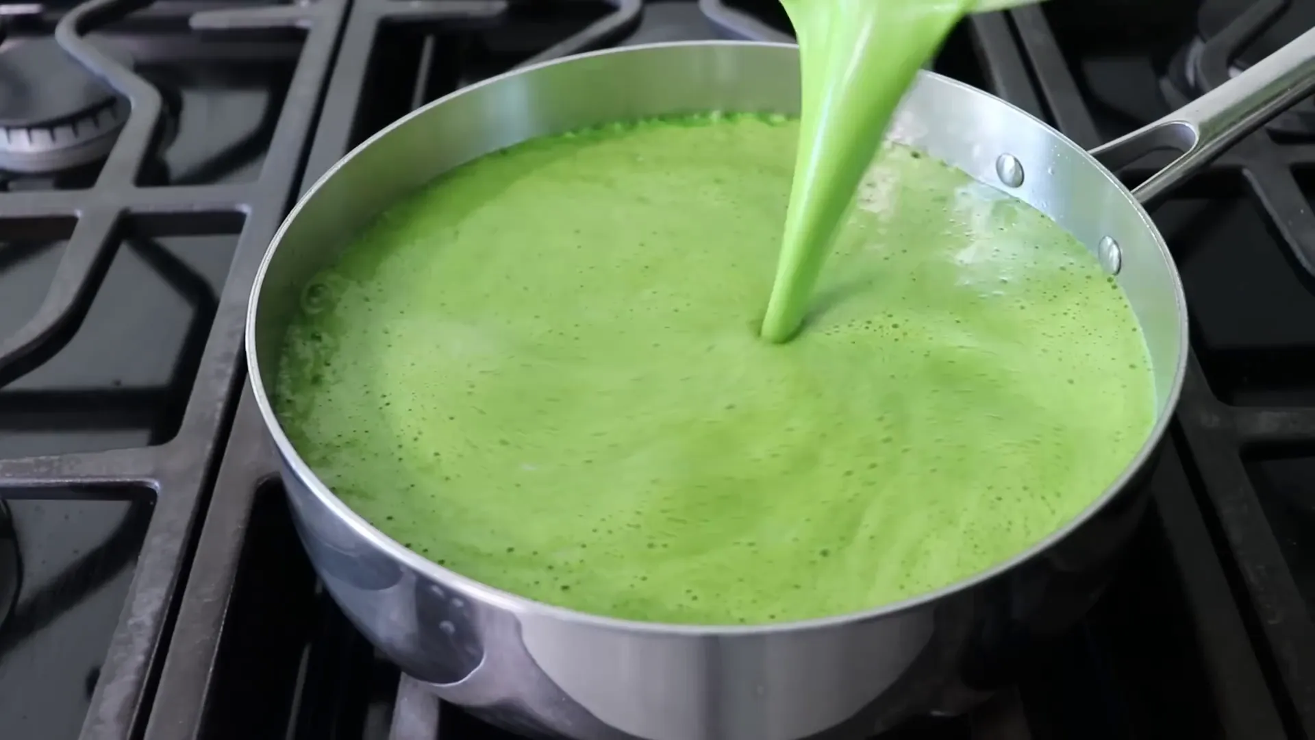 Pouring the bright green puree into the rice
