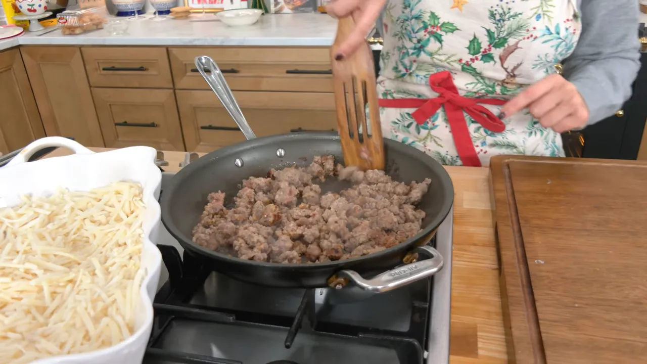 Evenly browned breakfast sausage in a skillet with hash browns in a baking dish at the ready
