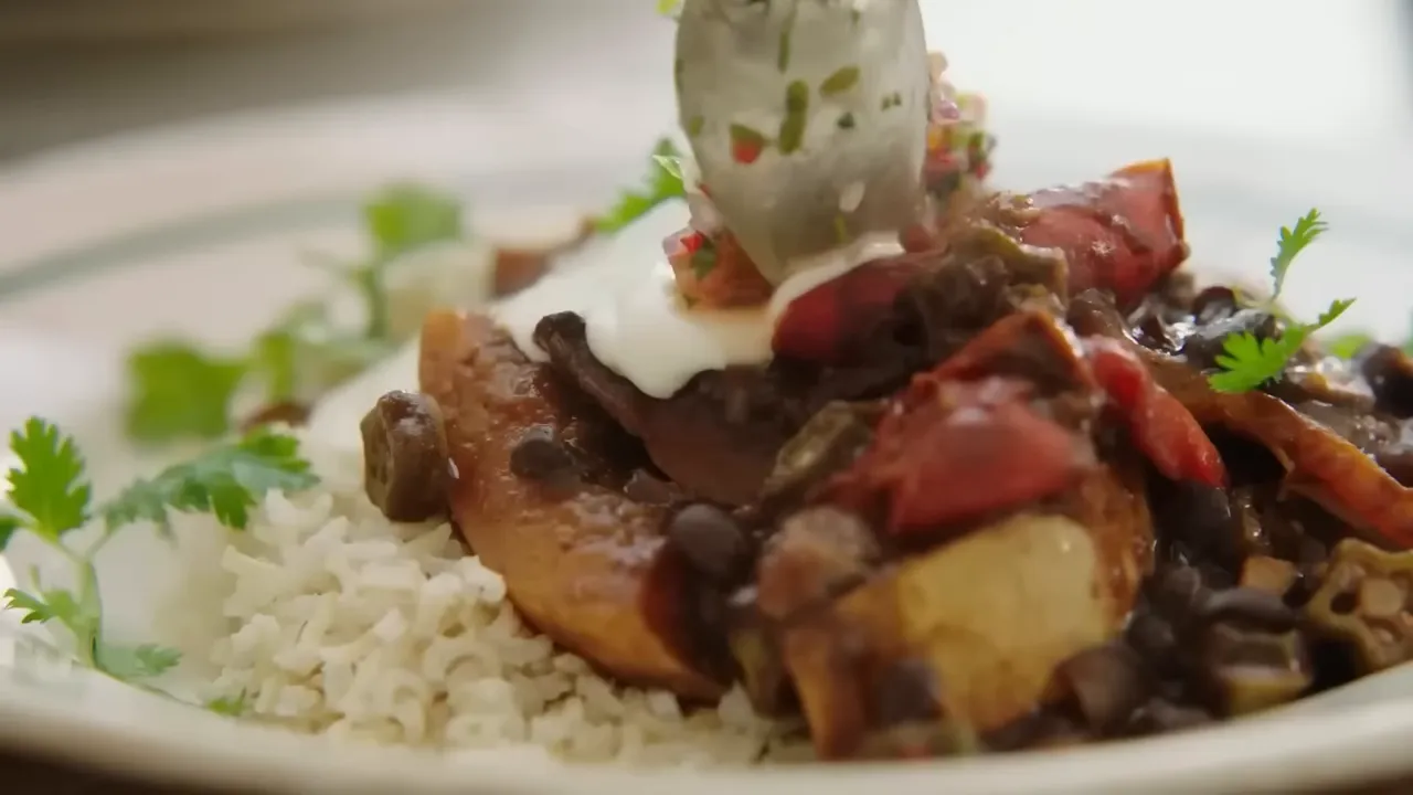 served bowl of smoky bean stew with rice, yogurt and salsa