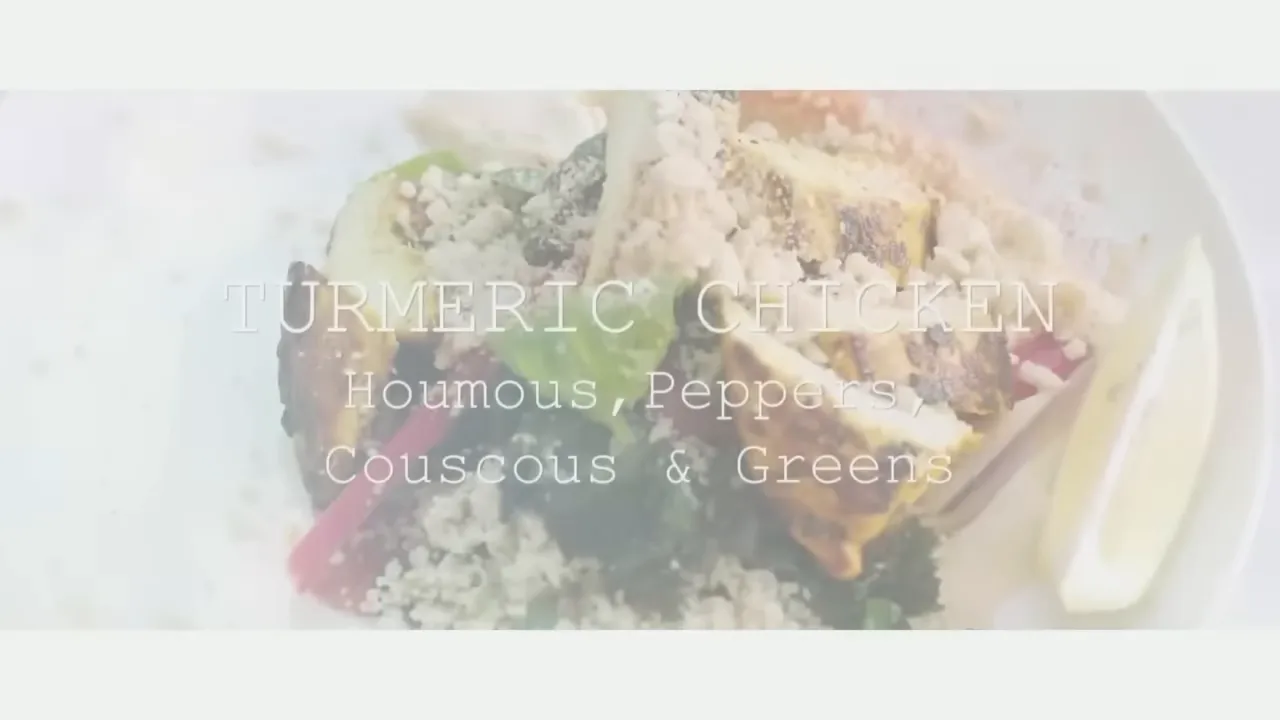 Plated turmeric chicken with couscous, silken hummus, roasted peppers, greens and a lemon wedge