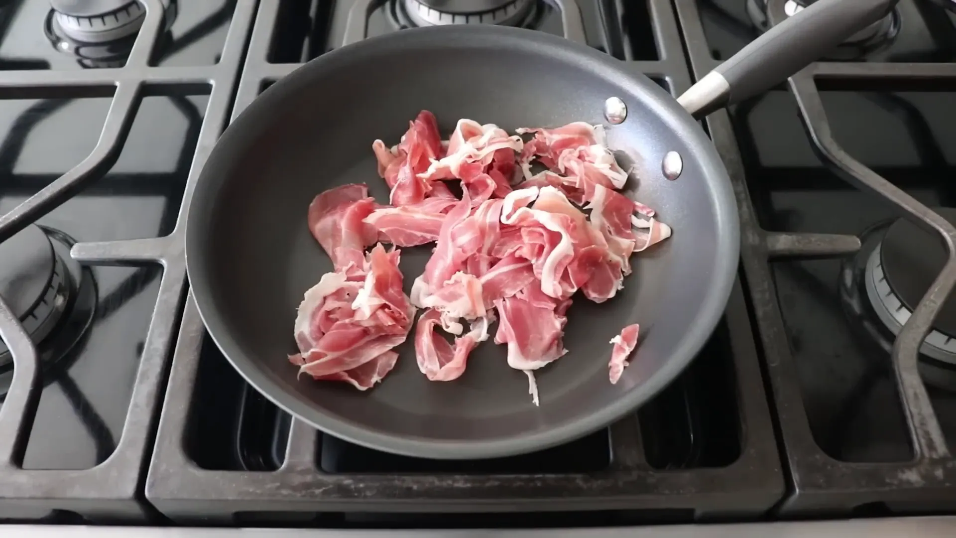 Sliced prosciutto sizzling in a dry pan