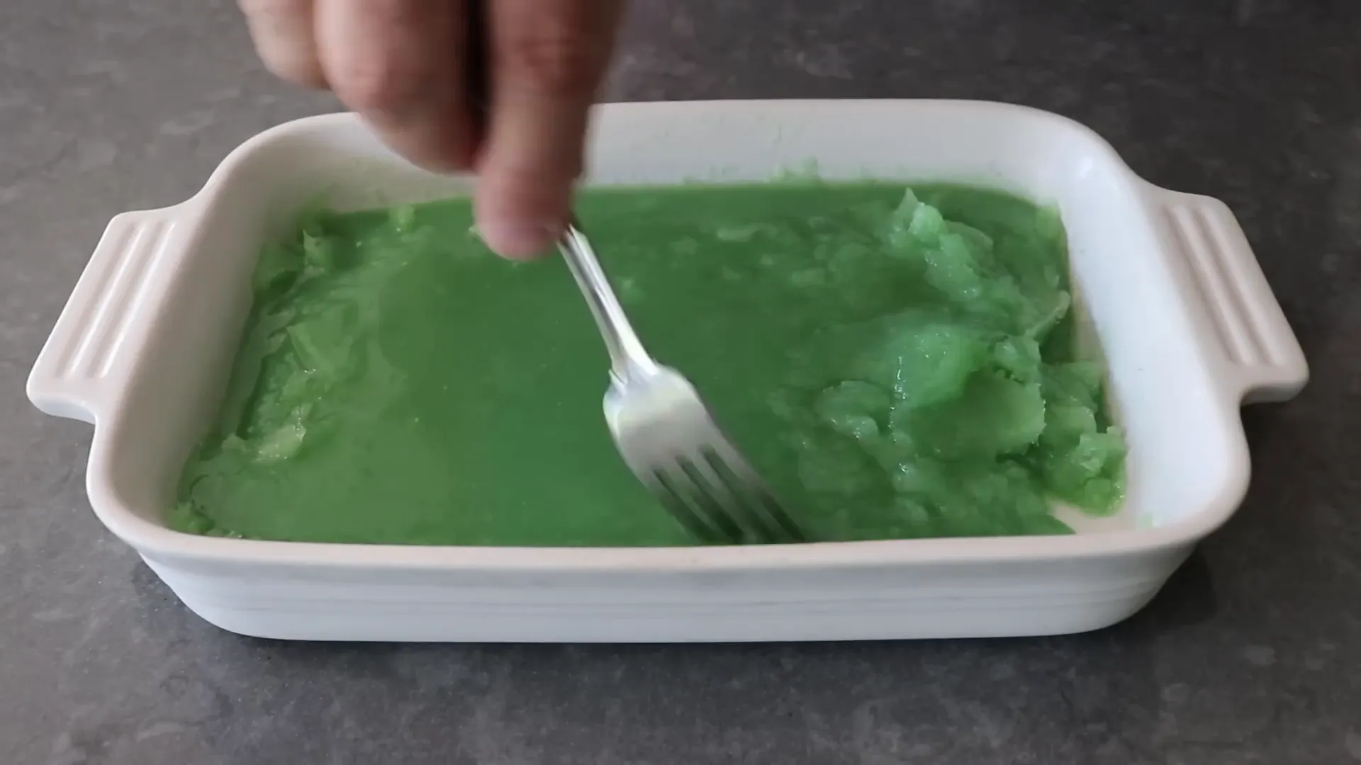 Forking slushy granita as it freezes to create fine crystals