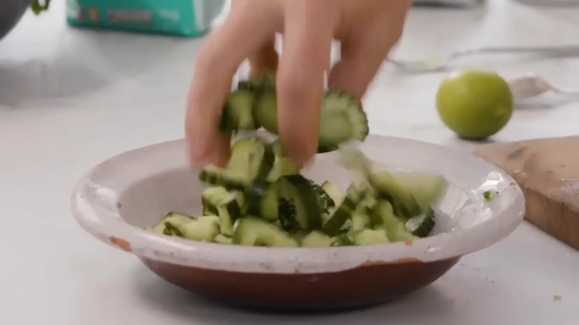 Quick cucumber pickle with lime and coriander being tossed