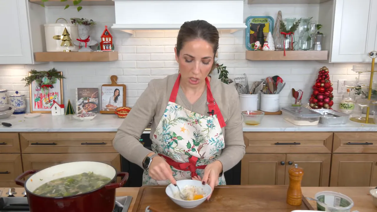 Mixing eggs and grated Parmesan in a bowl at a kitchen counter with a red Dutch oven of soup nearby.