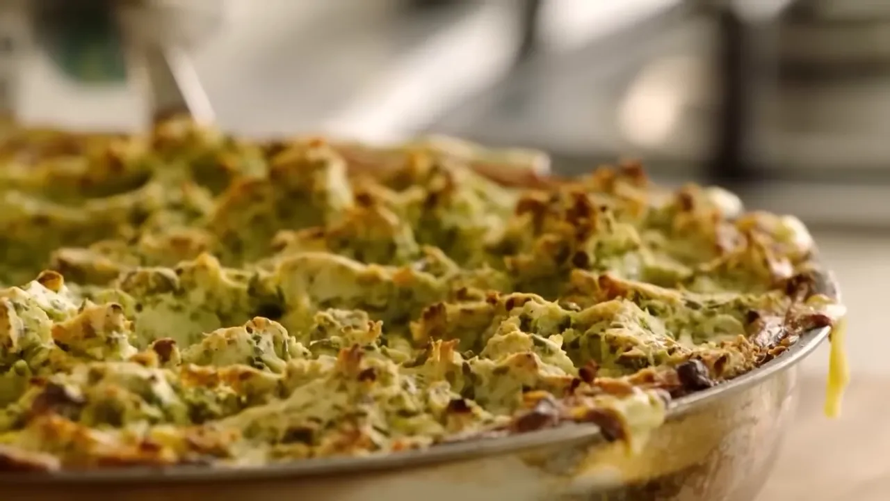 close-up of golden, crispy mashed potato topping with peas on a baked fish pie