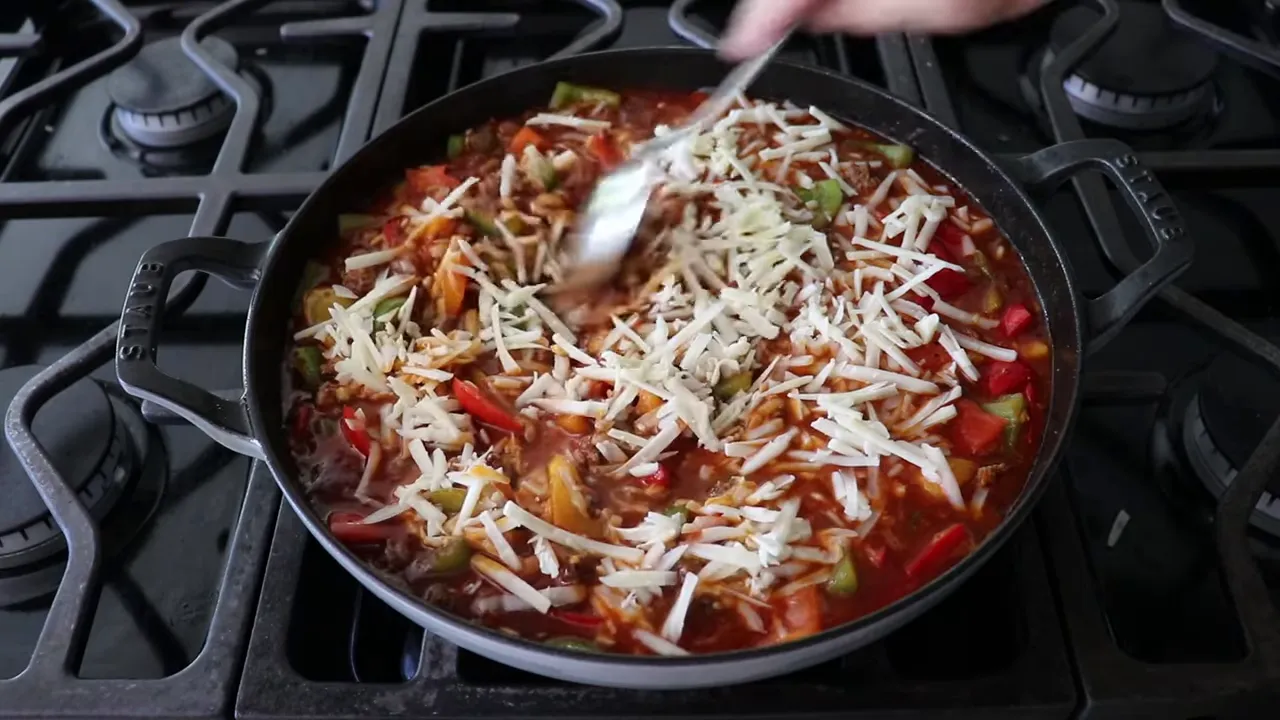 Mixing cheese into bubbling skillet before baking
