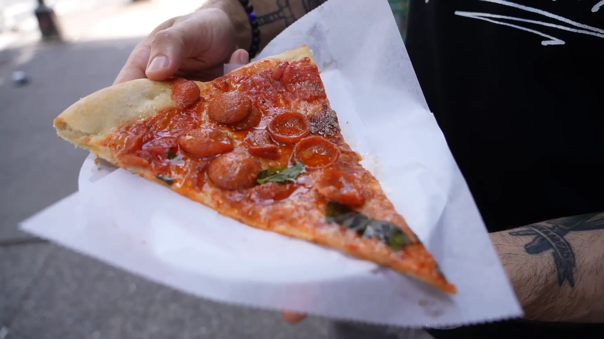 Di Fara's pizza slice with oily crust and fresh tomato sauce