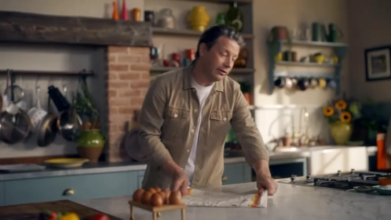 kitchen counter with eggs on a cloth and the presenter preparing ingredients