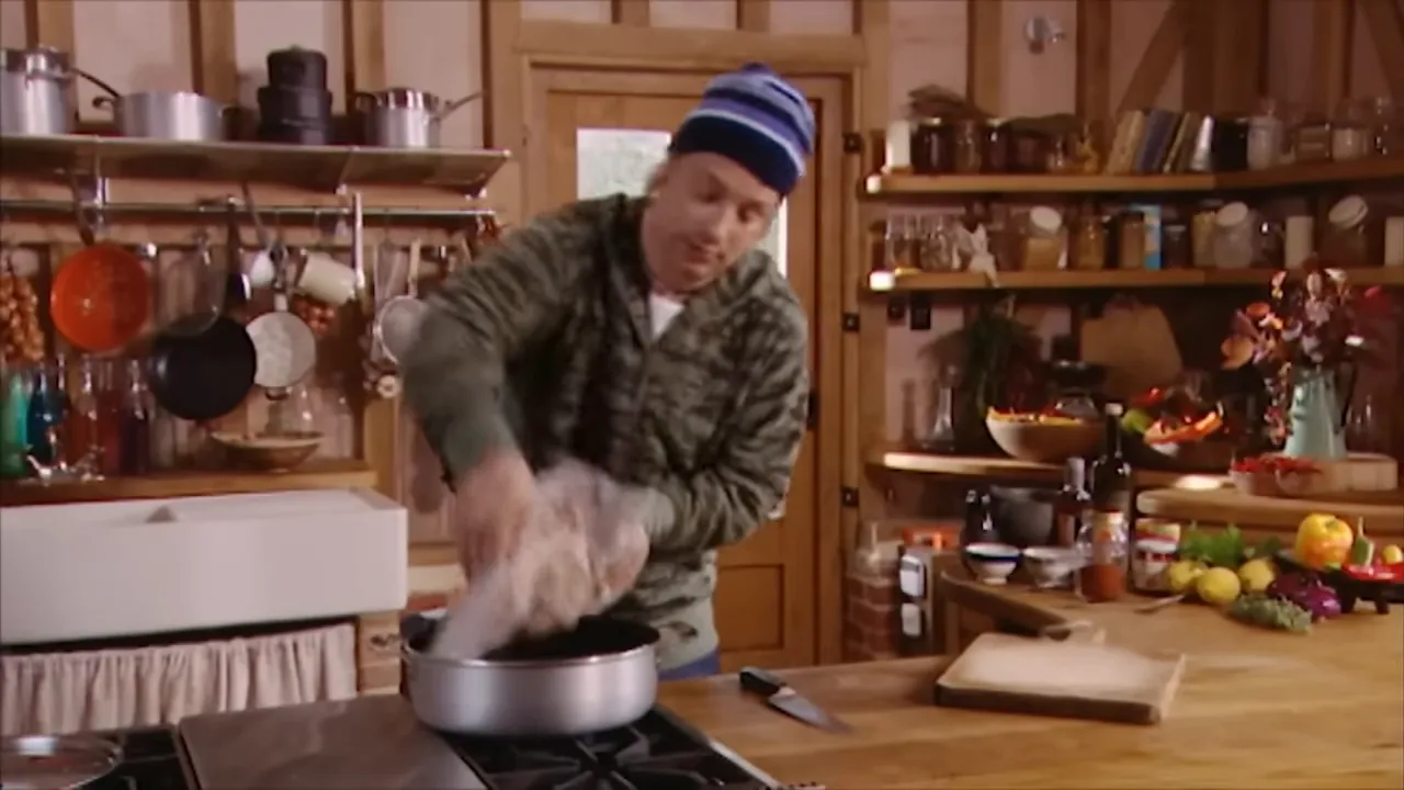 Scored pork shoulder sizzling in the pan