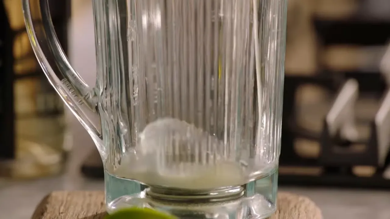close-up of a blender jug with lime juice at the bottom ready for blending