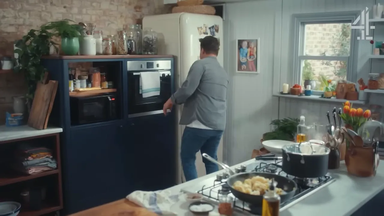 Stovetop scene with a frying pan of cauliflower and a saucepan in a bright home kitchen