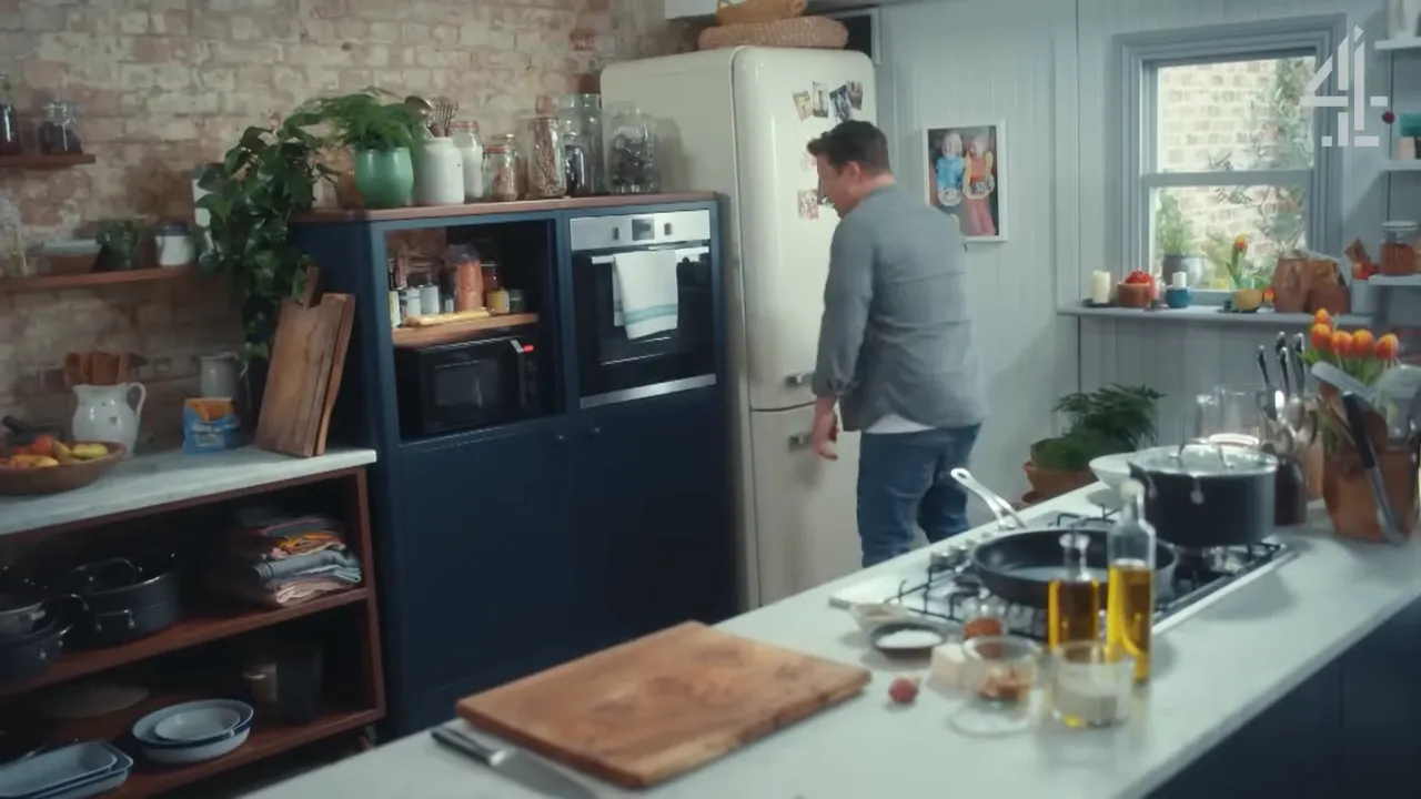 Home kitchen island with chopping board, oil bottles, pans and a person opening the fridge