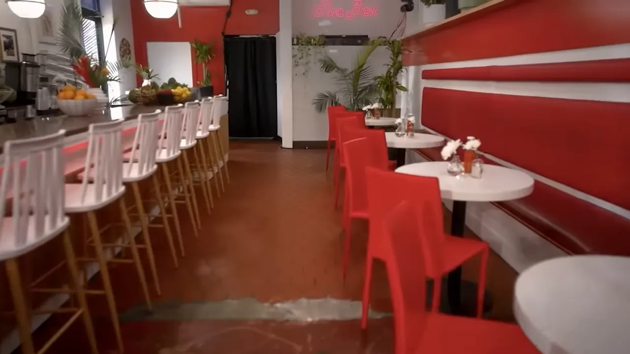 empty diner interior showing a long counter, bar stools and red seating