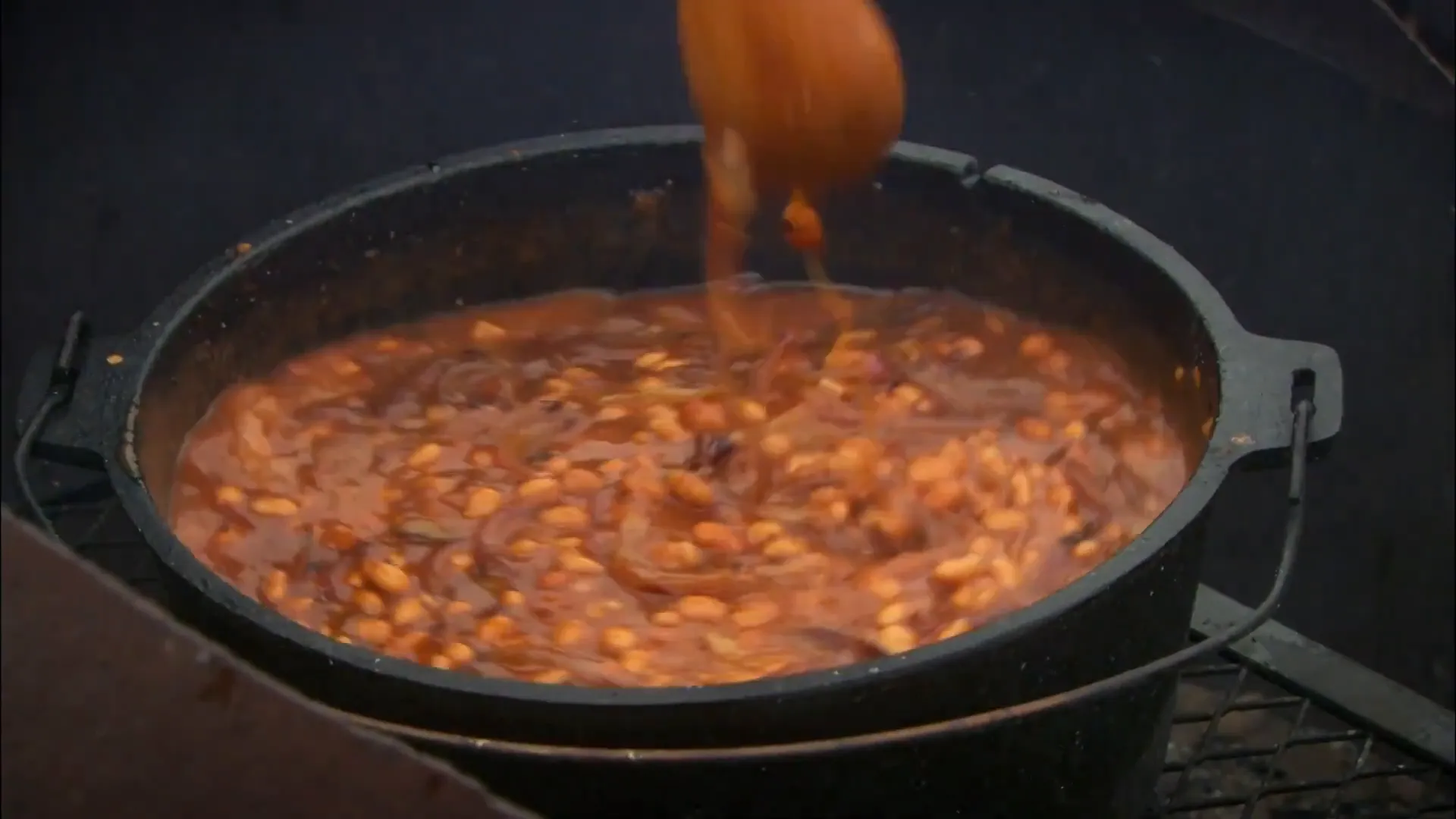 Dutch oven beef cooking over hot coals