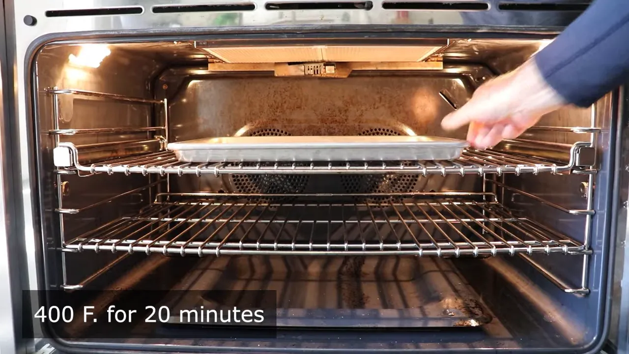 Baking sheet inside an oven with a tray being placed and on-screen text 400°F for 20 minutes