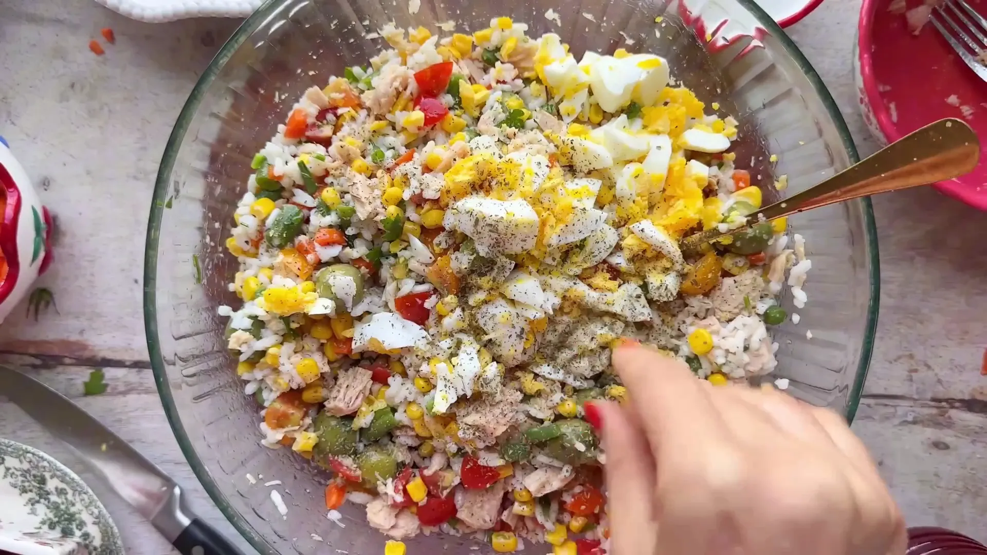 Adding diced hard-boiled eggs and herbs to the salad