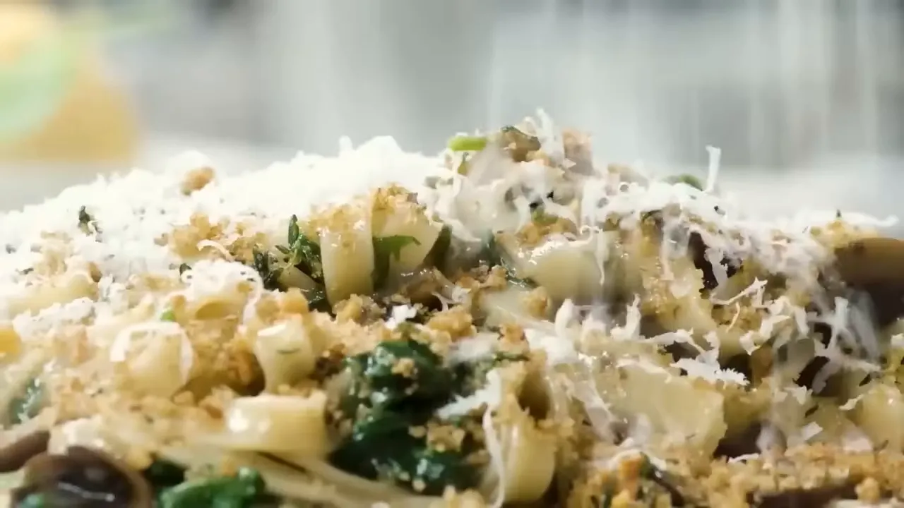 Close-up of mushroom pasta with wilted spinach, crunchy garlic breadcrumbs and grated parmesan