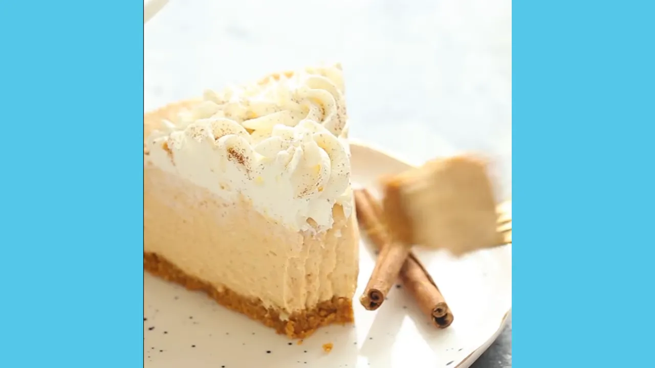 Slice of caramel apple crumble cheesecake with whipped cream and cinnamon sticks on a plate
