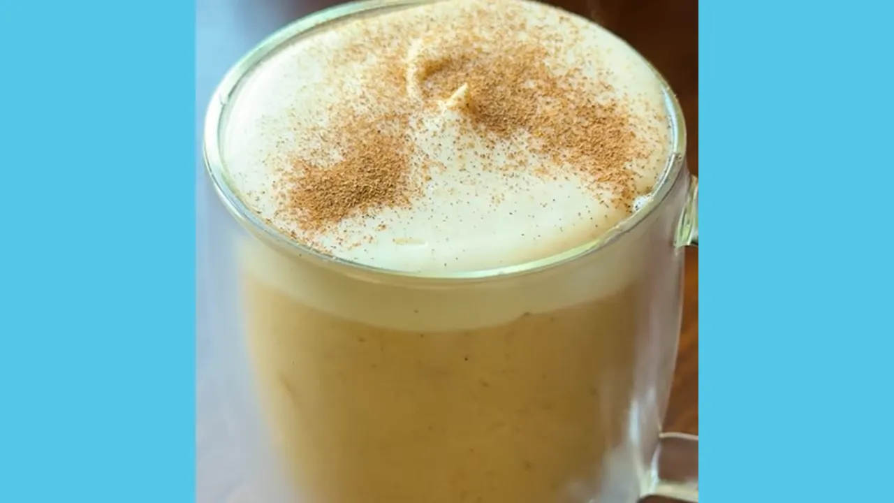 pumpkin spice latte cream mousse in a clear glass mug topped with foamed cream and pumpkin spice