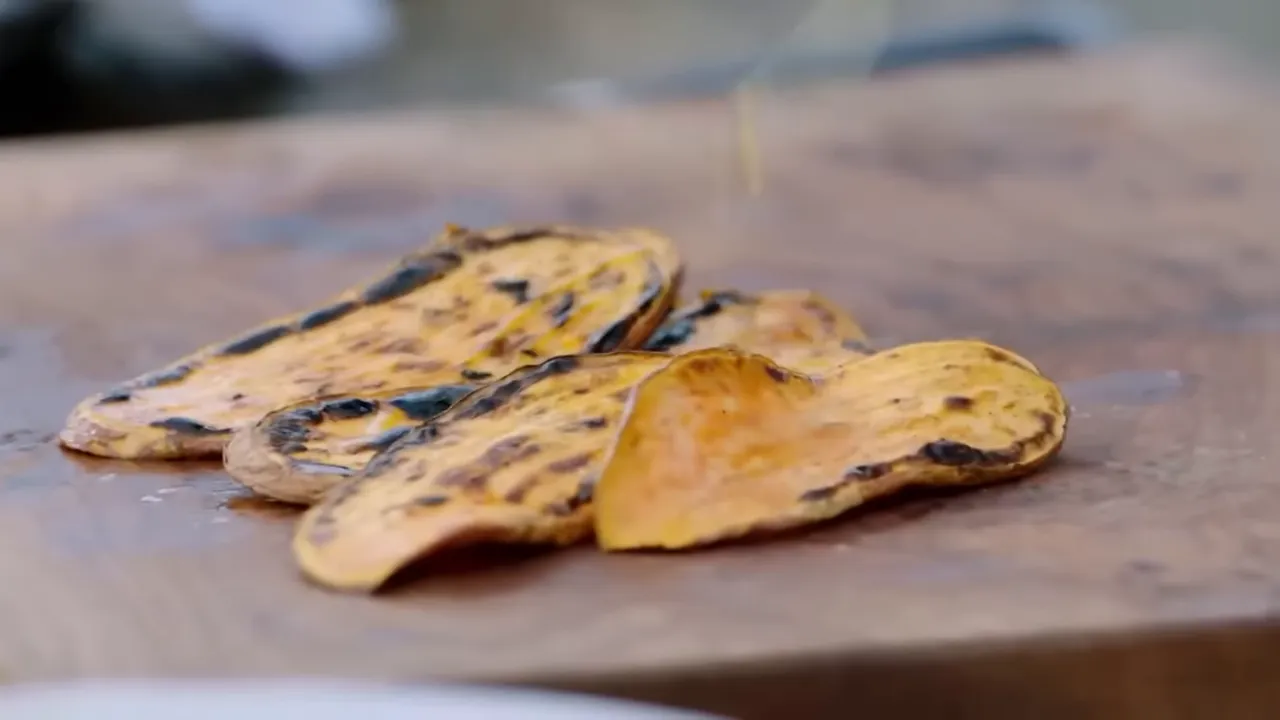 Charred sweet potato slices on the barbecue, nutty and caramelised