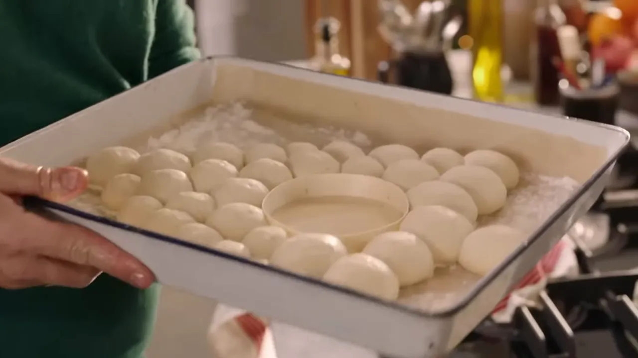 Tray of rolled bread dough balls arranged in a tree shape with a circular camembert space in the middle