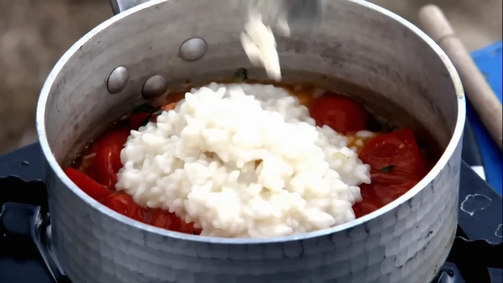 Cherry tomato and basil risotto being mixed