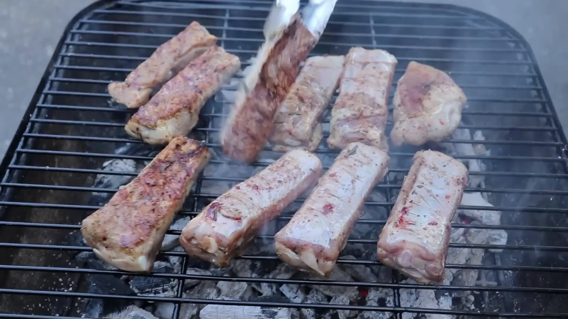 Ribs grilling on a hot charcoal grill with vents open