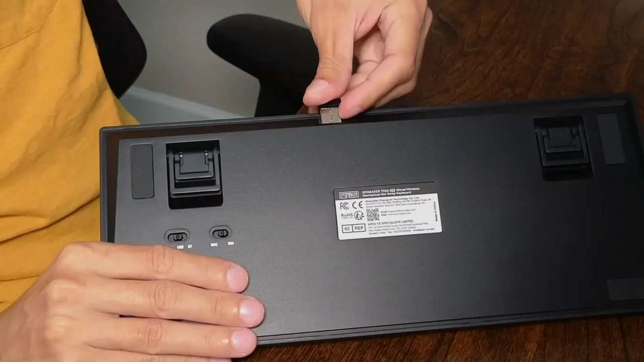 Epomaker TH80 SE underside with hand pulling the 2.4 GHz wireless USB dongle from its storage slot