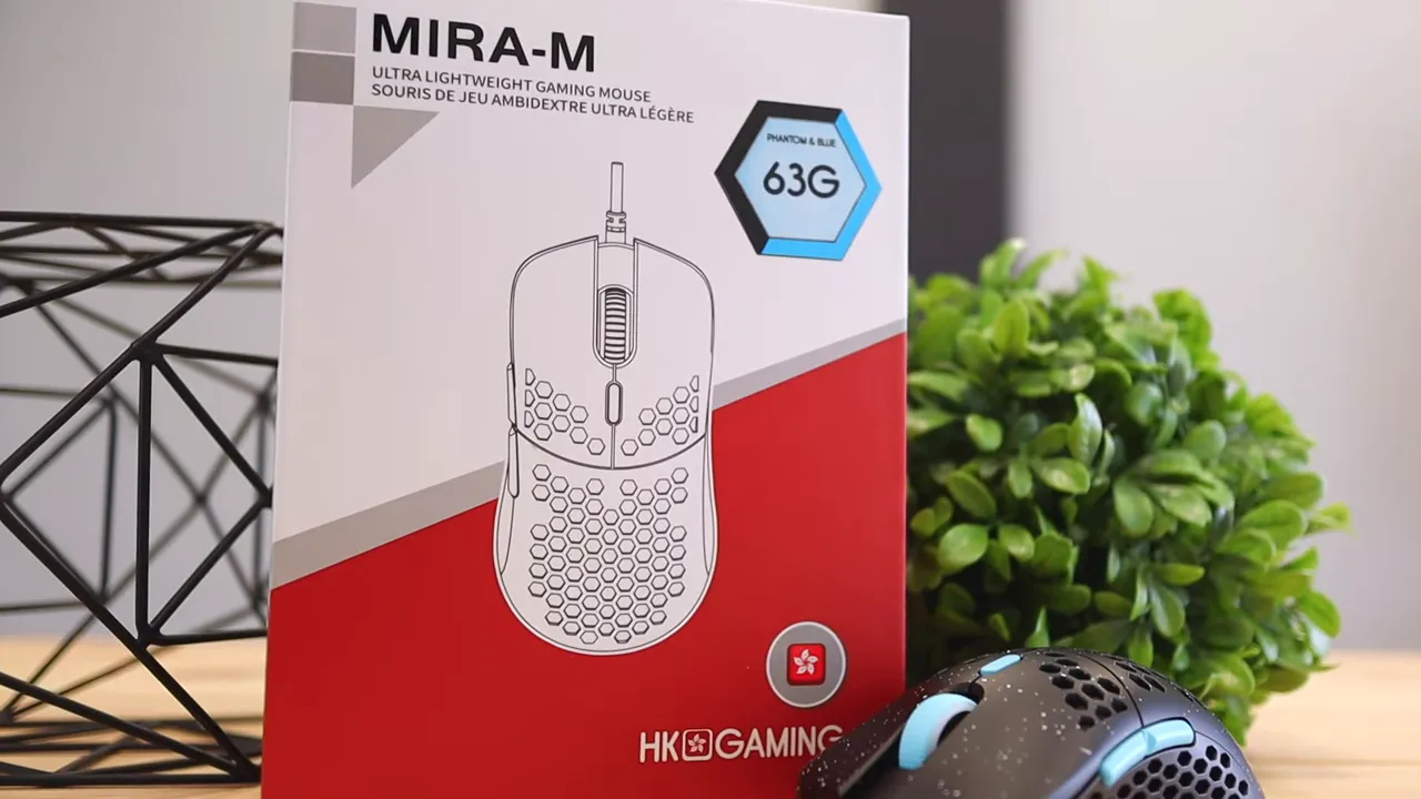 MIRA-M retail box beside the black honeycomb mouse with blue cable on a wooden desk