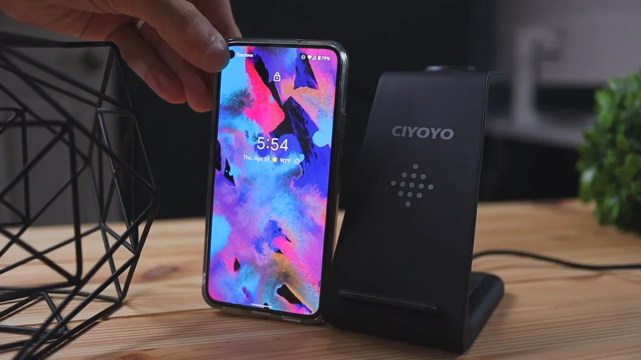 Black CIYOYO 3‑in‑1 wireless charging dock next to a phone on a wooden desk
