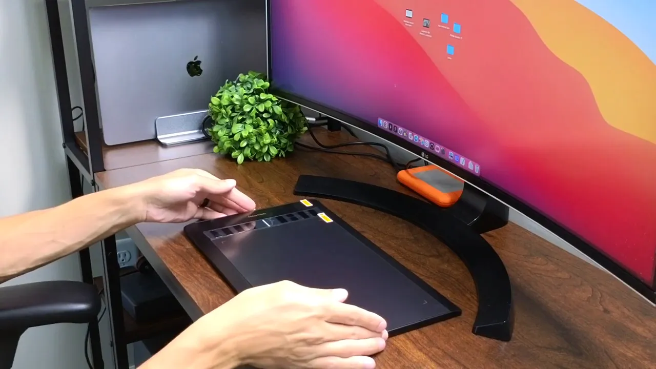 NEARHUB S13 drawing tablet on a wooden desk next to an ultrawide monitor, showing its slim profile and shortcut buttons