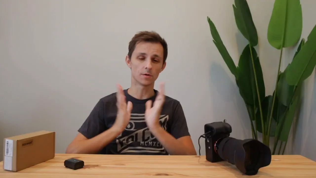 Neewer NP-FZ100 box, NP-FZ100 dummy battery and a Sony A7IV camera arranged on a wooden desk in a clean setup