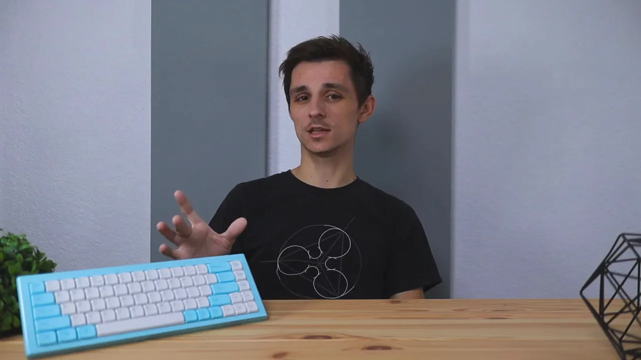 Reviewer presenting the Morgrie RKB 68 keyboard on a wooden desk