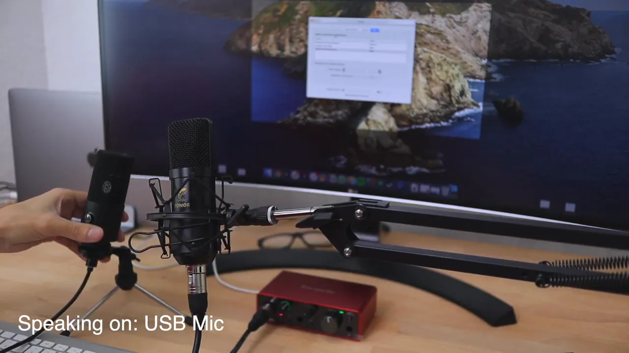 USB microphone mounted on boom arm in front of screen