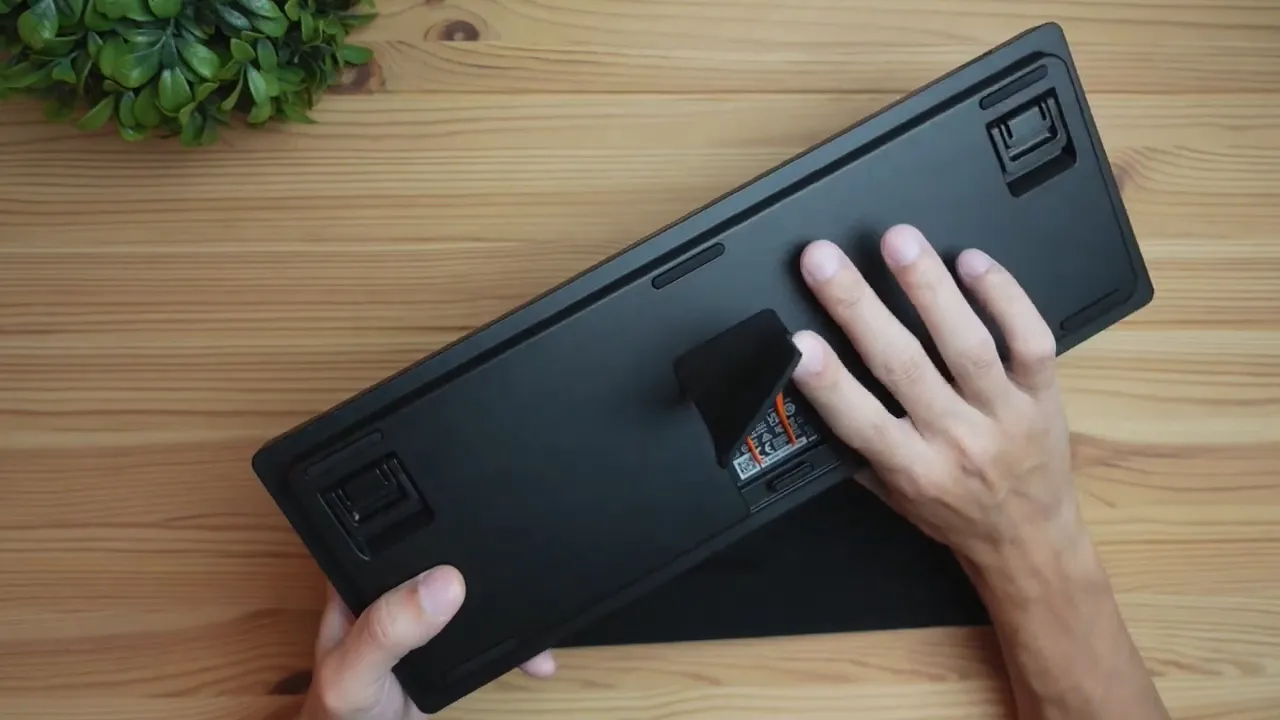 Clear top-down shot of the Apex Pro TKL underside with the keycap puller deployed and fold-out feet visible.
