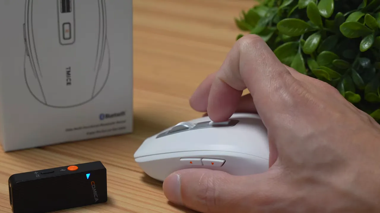 close-up of fingertip pressing left click on TMICE TKM01A mouse showing side buttons