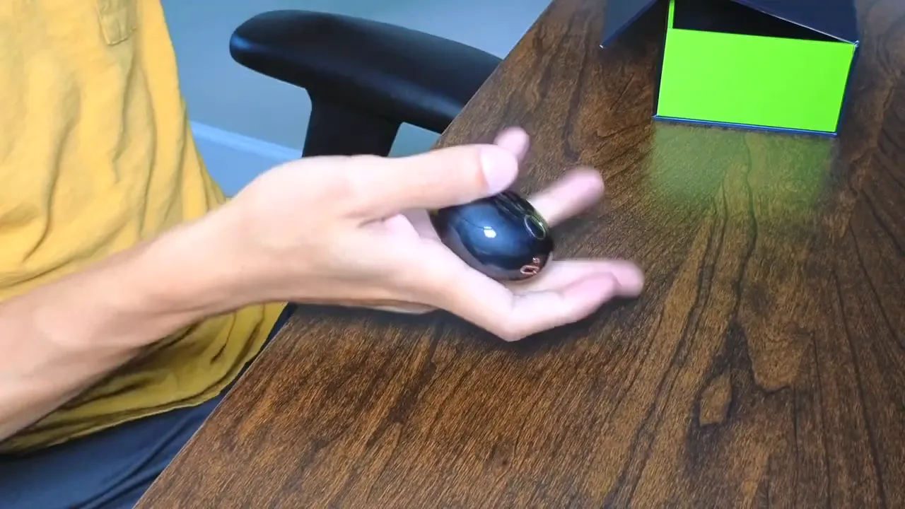 Mifo FiiTii HiFiDots glossy charging case held in hand on a wooden table