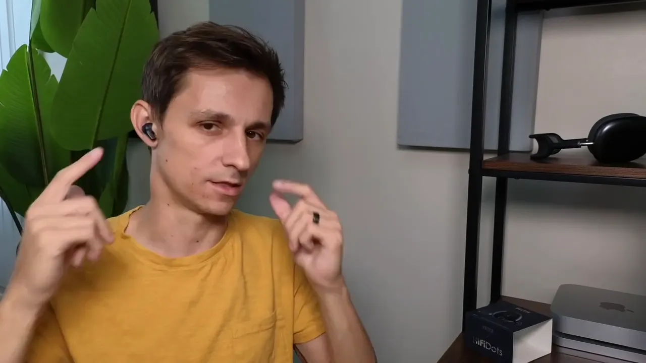Person pointing to Mifo FiiTii HiFiDots earbuds to demonstrate fit and the small wing stabilizer