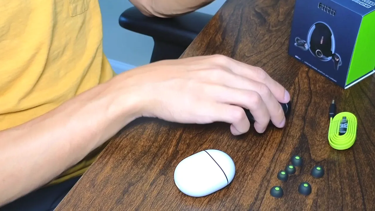 Mifo HiFiDots charging case, extra ear tips, lime short charging cable and product box on a wooden table