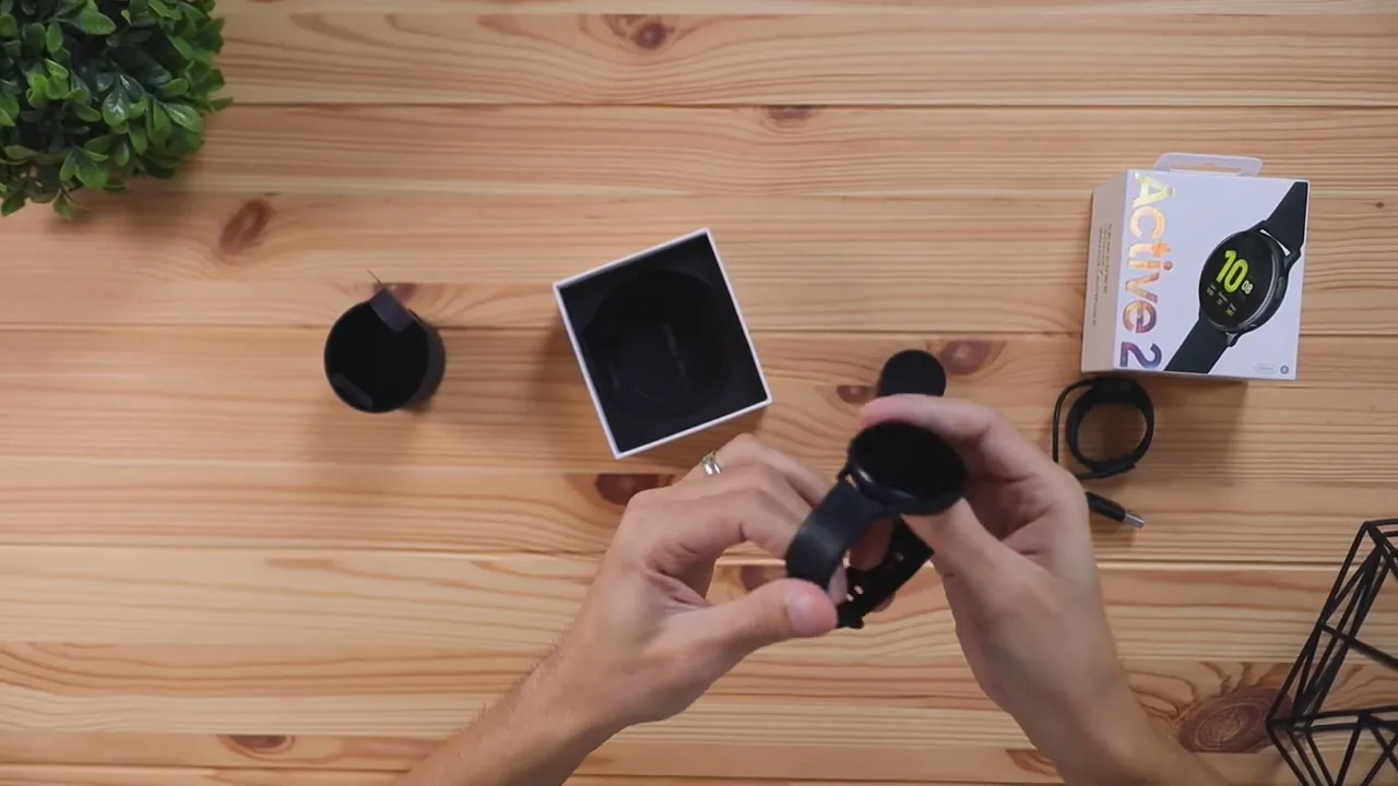 Hands adjusting the Samsung Galaxy Watch Active 2 strap connection points