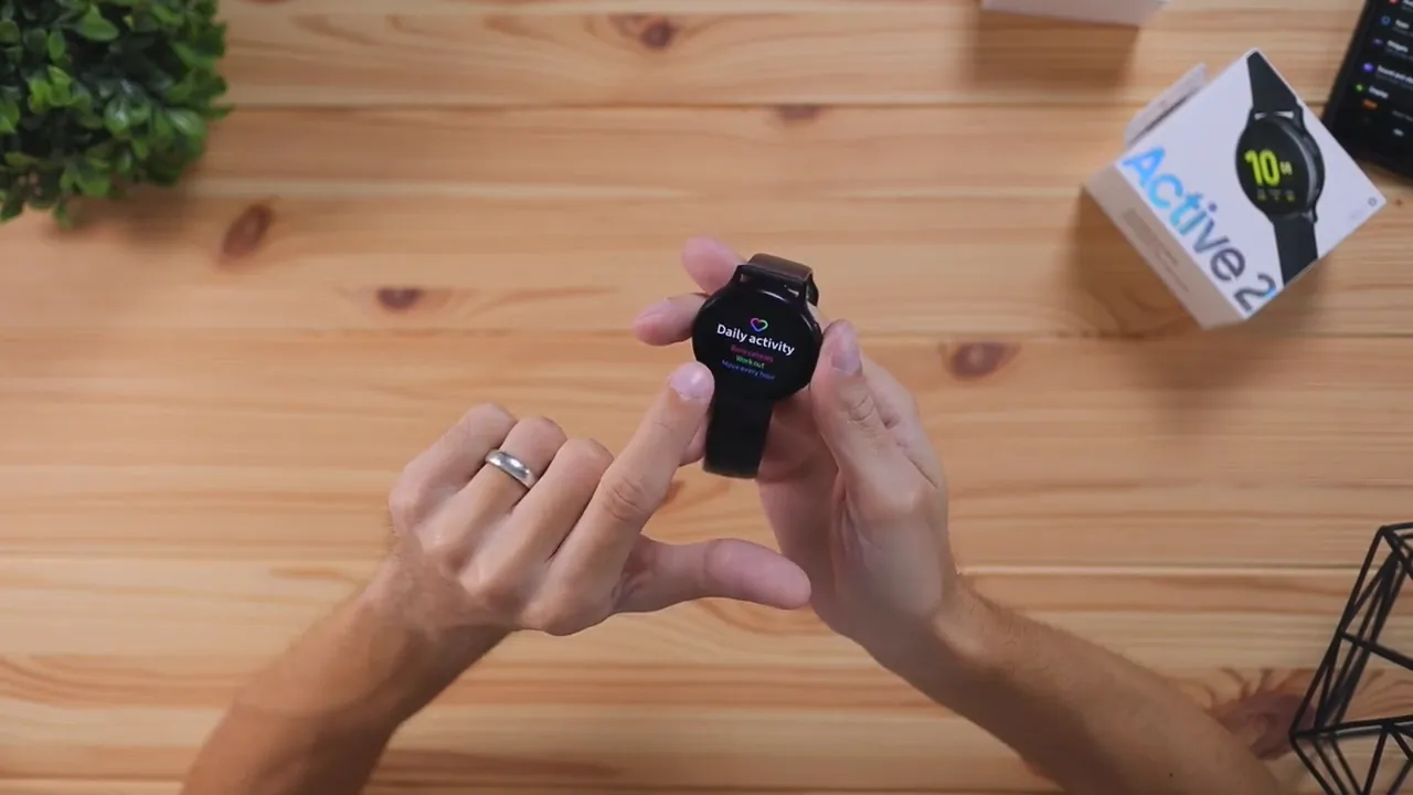 Samsung Galaxy Watch Active 2 with Daily activity screen visible in hands
