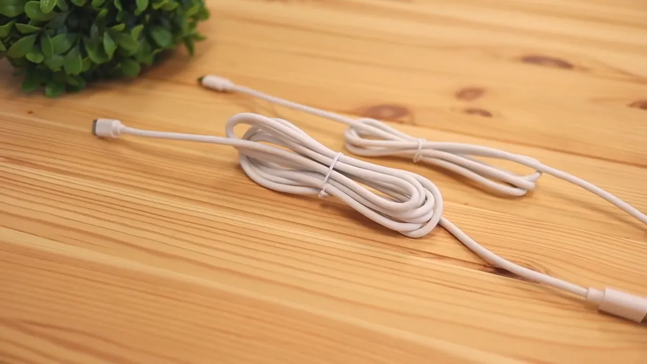 Two white keyboard cables laid on a wooden desk