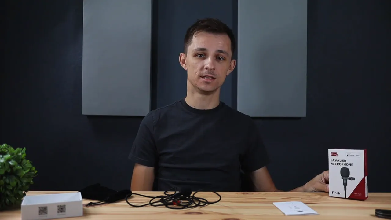 Pixel lavalier microphone and cable on the desk with its product box beside the presenter