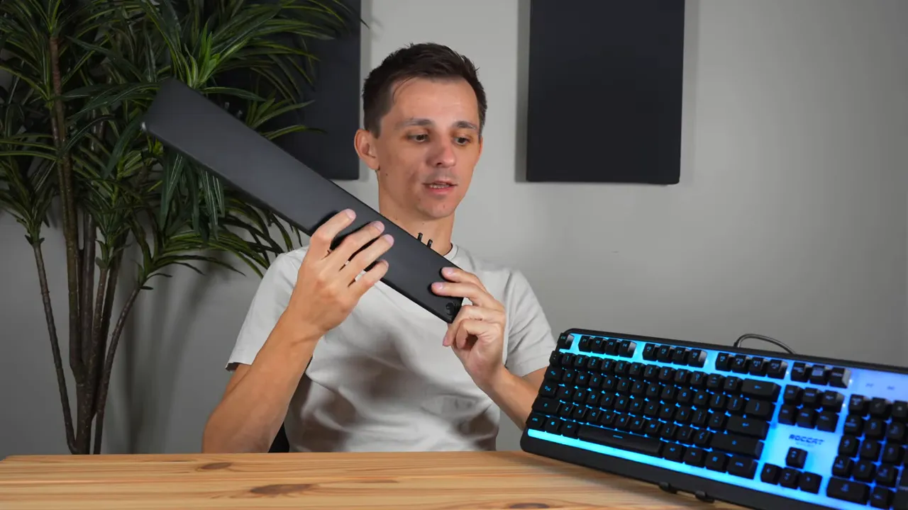 Removable plastic wrist rest held up beside the Roccat Magma keyboard showing attachment clips