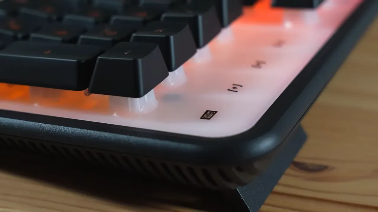 Close-up of Roccat Magma corner showing white RGB backplate, rubberized keycaps, and flip-out foot