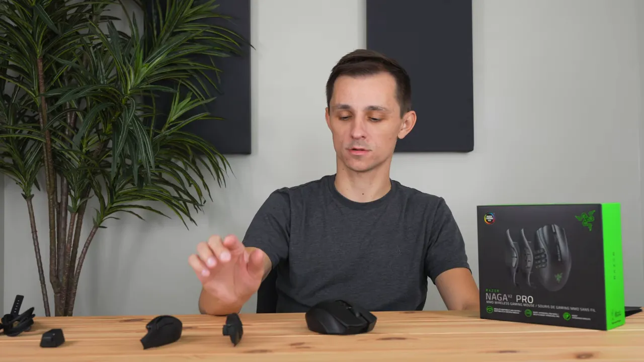 Razer Naga V2 Pro mouse with three detachable side plates and accessories arranged on a desk.